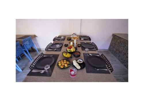 een lange tafel met borden met eten erop bij HR DUKES DEN RESORT in Rāmnagar