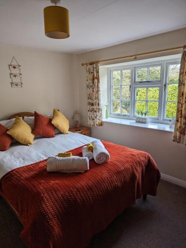 a bedroom with a bed with towels on it at Jasmine Cottage Lastingham North Yorkshire in Lastingham