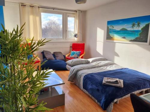 a bedroom with a bed and a couch and a chair at Comfy Nest near Angel and Old St in London