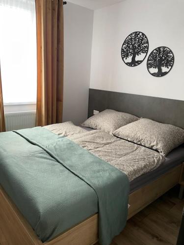 a bed in a bedroom with two trees on the wall at Rado apartments in Svit