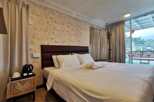 Un dormitorio con una cama con un osito de peluche. en OYO 89969 Mount Hill Villa Kundasang, en Ranau