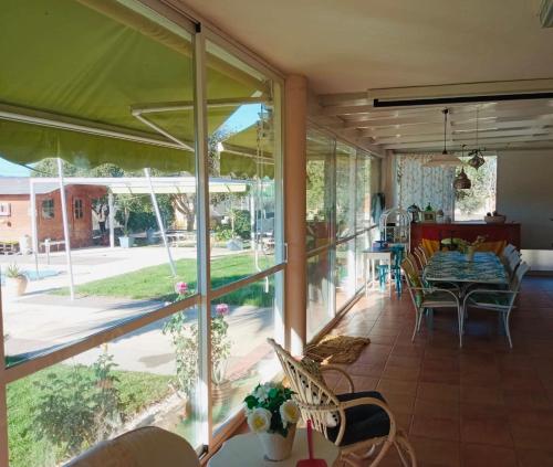 giardino d'inverno con porte in vetro, tavolo e sedie di Chalet La Calma en Lorca a Lorca