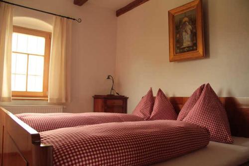 una camera con due letti con lenzuola a scacchi rosse e bianche di Kellerstöckl 