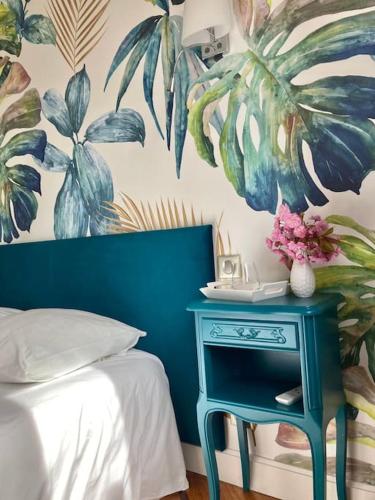 - une chambre avec une table bleue à côté d'un lit dans l'établissement Appartement avec jardin centre ville de Belfort, à Belfort