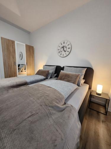 two beds in a bedroom with a clock on the wall at Landhaus Appartement in Bad Salzuflen