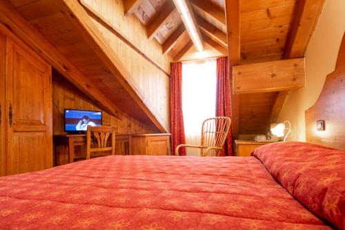 een slaapkamer met een bed en een televisie in een kamer bij Locanda Alla Stella in Roana