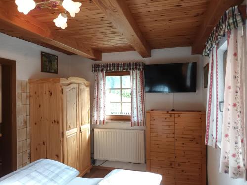 a bedroom with a bed and a tv and a window at Umundum Hütte in Katsch Oberdorf