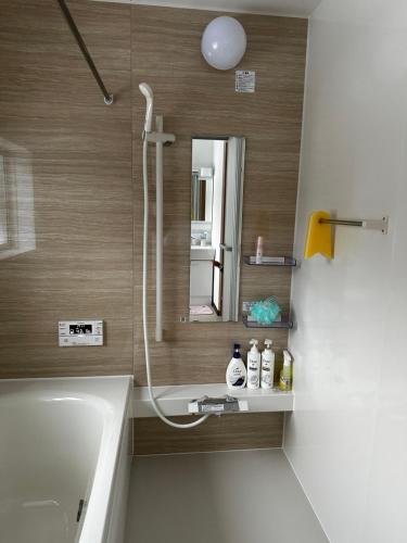 a bathroom with a shower and a sink and a mirror at Urasa Cottage @ Snow Countryside in Minami Uonuma
