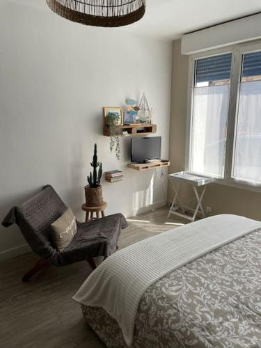 une chambre avec un lit, une chaise et une fenêtre dans l'établissement Les Valéricaines - Studio en plein cœur de la cité médiévale, à Saint-Valery-sur-Somme