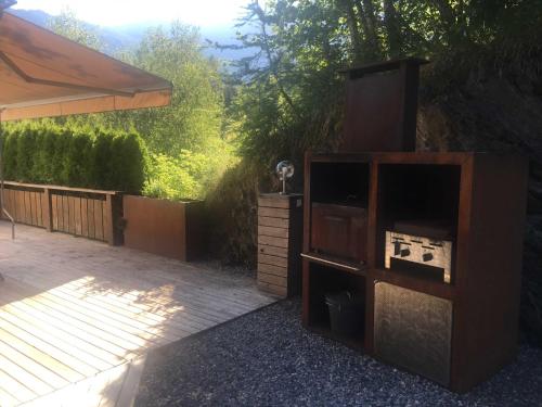 a wooden entertainment center in a yard next to a patio at Ferienhaus Piburg in Oetz