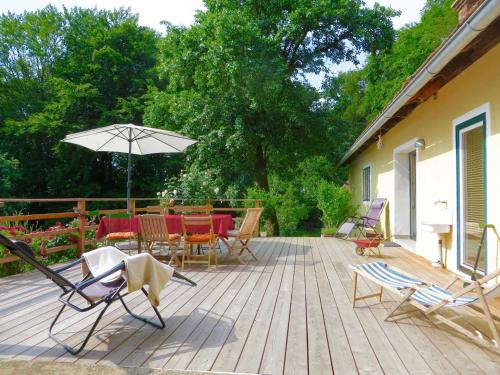 una terrazza con tavolo, sedie e ombrellone di Ferienhaus Baumgarten1 a Gnas