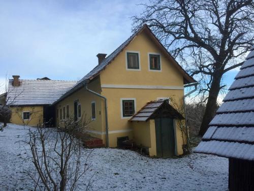 a yellow house with snow on the ground at Ferienhaus Baumgarten1 in Gnas