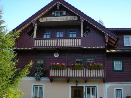 a wooden house with flowers on the balcony at Ferienhaus Tschernitz in Pruggern