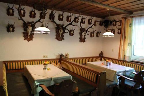 a restaurant with two tables and antlers on the wall at Bauernhof Huber in Wenns