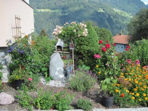 a garden with colorful flowers and a bird feeder at Bauernhof Huber in Wenns