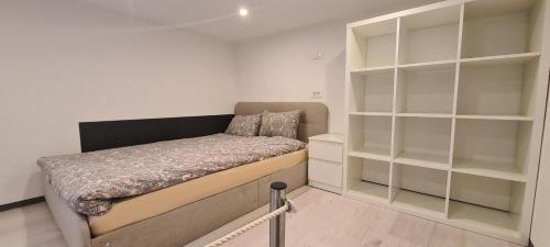 um pequeno quarto com uma cama e prateleiras em AMB center point em Ljubljana