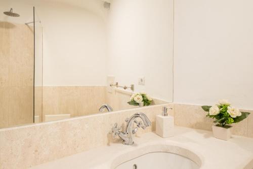 a bathroom with a sink and a mirror at [CALA DI VOLPE] Vista Mare e Piscina in Abbiadori