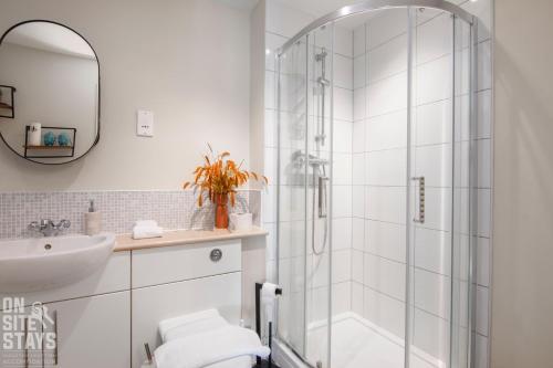 a white bathroom with a shower and a sink at OnSiteStays 2BR, Parking, Wifi, Shops and Restaurants Close in Hatfield