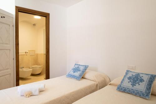 a room with two beds and a bathroom with a mirror at [CALA DI VOLPE] Vista Mare e Piscina in Abbiadori