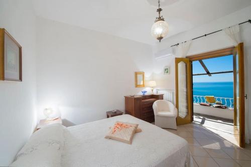 a bedroom with a bed and a view of the ocean at Elegant house overlooking the sea, easy park, wifi in Praiano