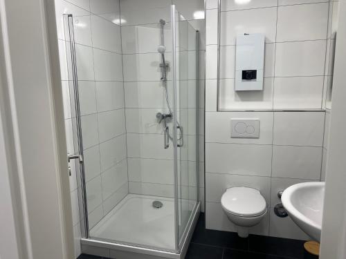 a bathroom with a shower and a toilet and a sink at RUEHOME in Essen