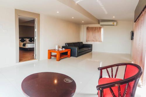 a living room with a table and a couch at Eastiny Inn Hotel in Pattaya