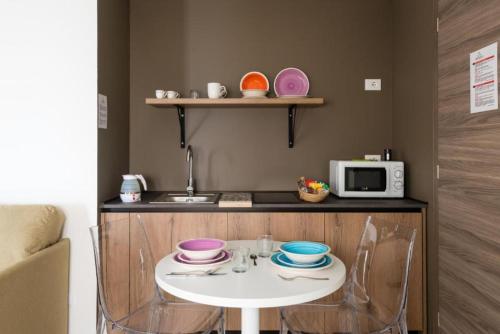 a small kitchen with a table and a microwave at Archinuè in Siracusa