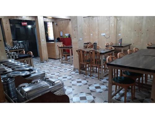 a restaurant with tables and chairs in a room at HOTEL HIMGIRI, Shri Badrinath in Badrinath