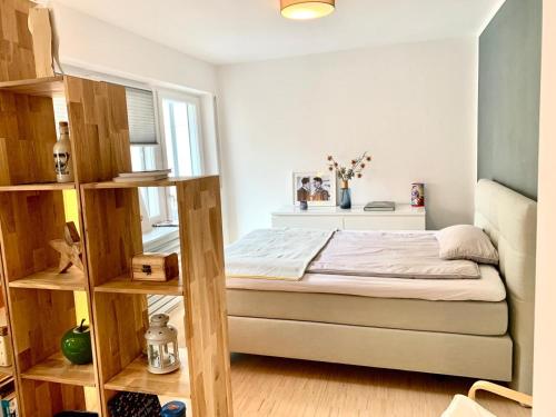 małą sypialnię z łóżkiem i półkami w obiekcie Zimtstern-West w Stuttgarcie