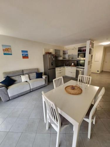 une table blanche et des chaises dans un salon dans l'établissement Appartement Ambassadeur, à Menton