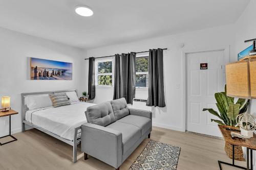 ハリウッドにあるYoung Circle & Hollywood Blvd Posh Studio Suiteのベッドとソファのある白い寝室