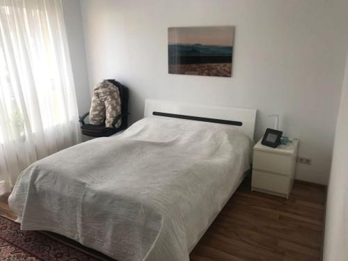 a bedroom with a white bed and a window at Goethe Apartment in Hannover