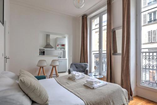 une chambre blanche avec un lit et une fenêtre dans l'établissement 338 Suite Montmartre - Superb apartment in Paris, à Paris