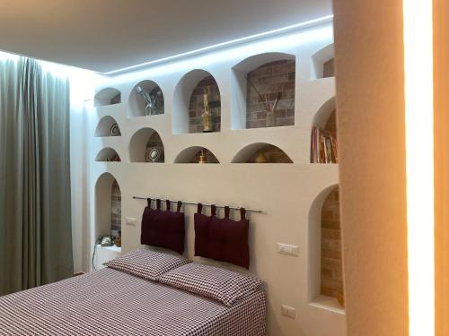 a bedroom with a bed with two pillows and shelves at La noce spaccata, casa vacanze in Macchia dʼIsernia