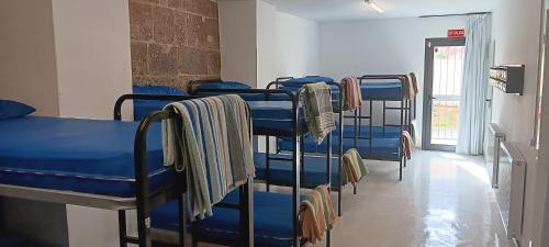 eine Reihe blauer Etagenbetten in einem Zimmer in der Unterkunft Albergue Santiago Apostol in Logroño
