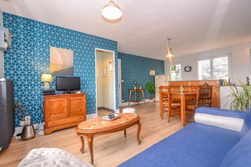 un salon avec un canapé et une table dans l'établissement Les Valéricaines - Bel appartement - vue sur les toits de St Valéry, à Saint-Valery-sur-Somme