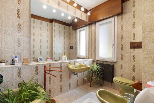 a bathroom with a sink and a green toilet at Il giardino di Giò in Finale Ligure