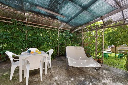 a patio with a table and chairs and a pergola at Il giardino di Giò in Finale Ligure