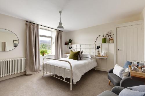 a bedroom with a bed and a chair and a window at Chestnut Villa in Grasmere