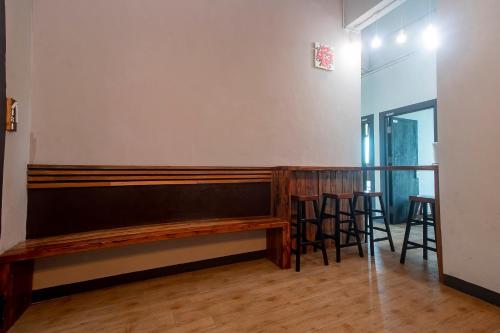 a bar with a wooden bench and stools at Hotel O Hi Inn 3 in Sibu