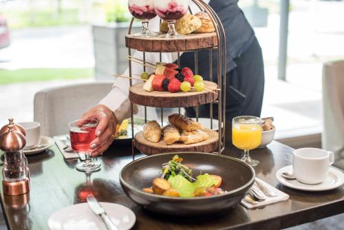 基勒纳德The Heritage的一个人站在桌旁，桌上放着一盘食物。