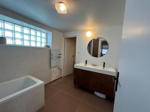 une salle de bain avec une baignoire, un lavabo et un miroir dans l'établissement 