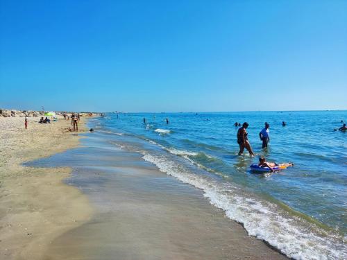 un groupe de personnes dans l'eau à la plage dans l'établissement Villa Douceur de Vivre à 15 min de la plage, à Villeneuve-lès-Maguelone