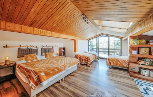 een grote slaapkamer met 2 bedden en een houten plafond bij Pet Friendly Home In Mechowo With Kitchenette in Mechowo