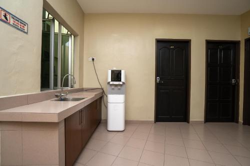 a kitchen with a sink and a refrigerator in a room at OYO 1194 Best Stay Hotel Pangkor in Pangkor