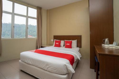 a bedroom with a large bed with red pillows at OYO 1194 Best Stay Hotel Pangkor in Pangkor