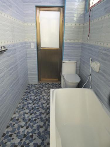 a bathroom with a tub and a toilet and a window at YahVilla Homestay in Baguio