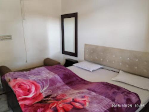 een slaapkamer met een bed met een bloemendeken erop bij Goroomgo Shah Guest House Nainital - Excellent Customer Service in Nainital