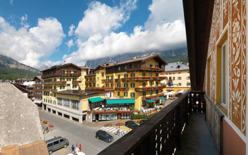 een balkon met uitzicht op een stad met gebouwen bij Hotel De La Poste in Cortina dʼAmpezzo