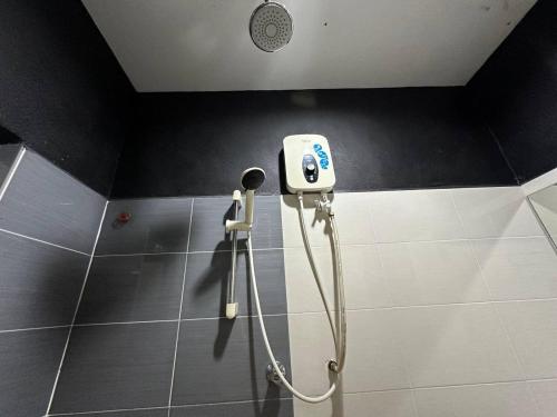 a shower in a bathroom with a phone on the wall at OYO 90938 The Nk Langkawi in Kampung Padang Masirat